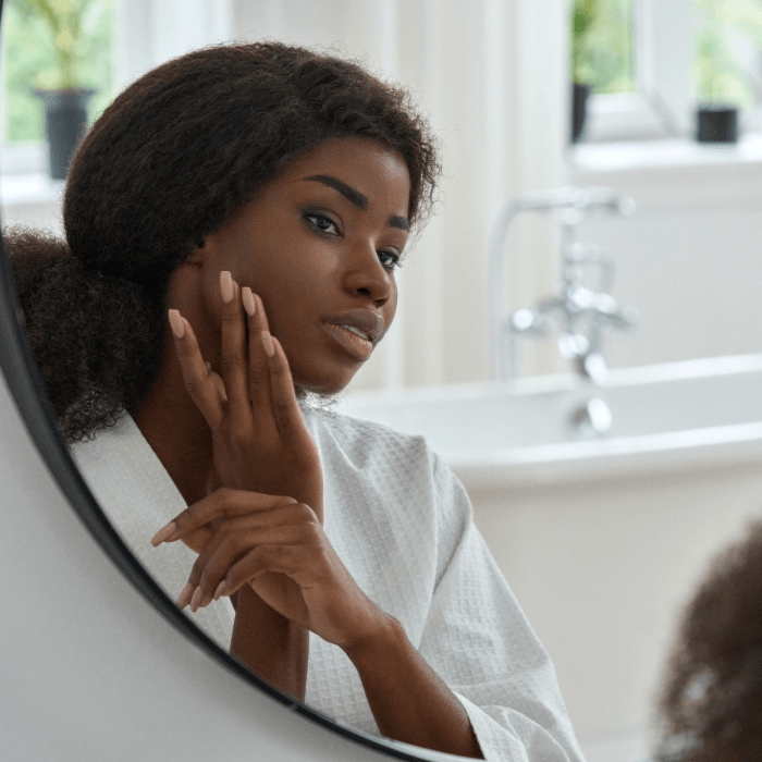Young woman looks at clear skin after treatment